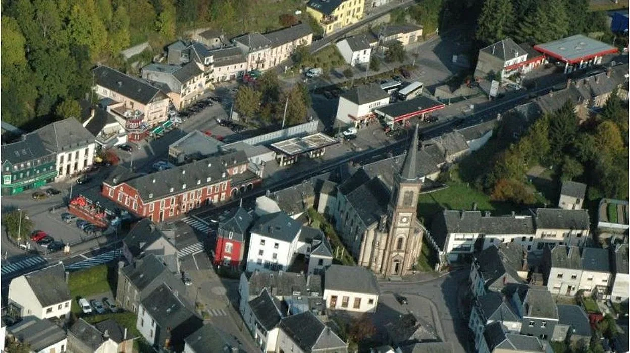 Vue aérienne de Martelange : toits, clocher et vallée boisée